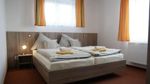 a bedroom with two beds with pillows on them at Farma Moulisových in Nezvěstice