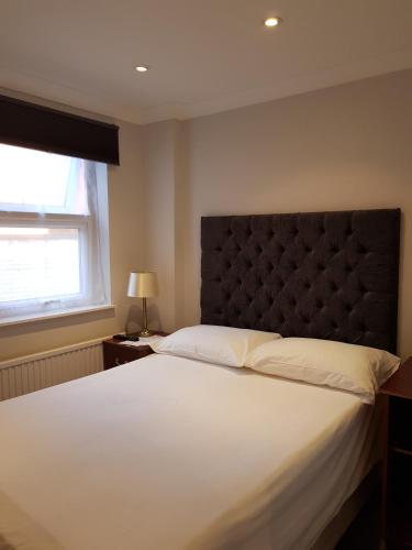 a bedroom with a large white bed and a window at Blagrave Rooms in Reading
