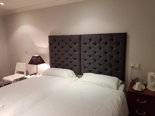 a bedroom with a large white bed with a black headboard at Blagrave Rooms in Reading