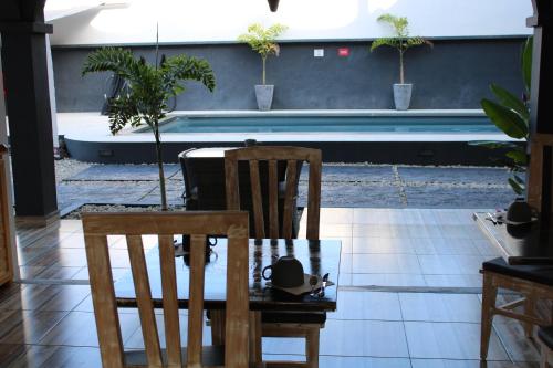 a table and a chair with a hat on it at Le Pôle in Grand Baie