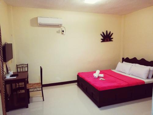 a bedroom with a bed with a red blanket at Sunrise Garden Lake Resort in Lahit