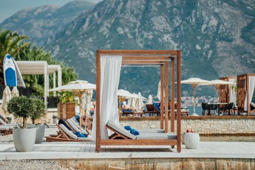 a group of lounge chairs and umbrellas at a resort at Boutique Hotel & Spa Casa del Mare - Mediterraneo in Herceg-Novi