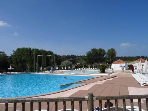 une grande piscine avec des chaises longues blanches. dans l'établissement Appartement vue sur golf, à Talmont-Saint-Hilaire