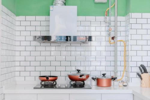 a kitchen with two pots and pans on a stove at Xi'an Lianhu·Moslem Street (Huimin Jie)· Locals Apartment 00172050 in Xi'an