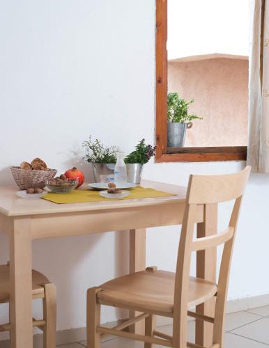 a table with two chairs and a table with a mirror at Anna Maria in Malia