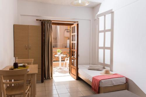 a bedroom with a bed and a desk and a table at Anna Maria in Malia