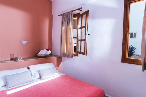 a bedroom with a bed with a window and a red blanket at Anna Maria in Malia
