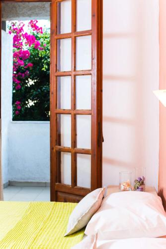 a door to a room with a bed and a window at Anna Maria in Malia