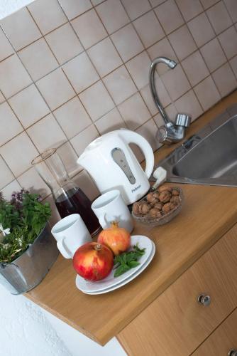 a counter with apples on a plate and a sink at Anna Maria in Malia