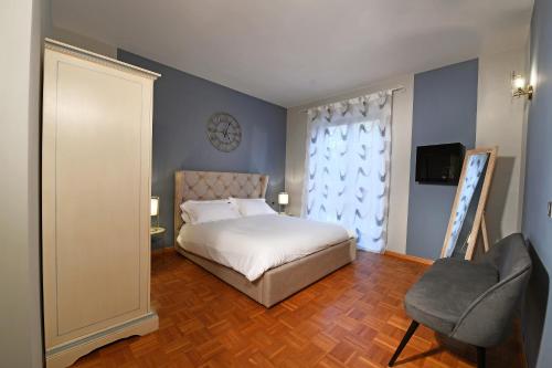 a bedroom with a bed and a chair and a window at Villa Garassino in Treiso
