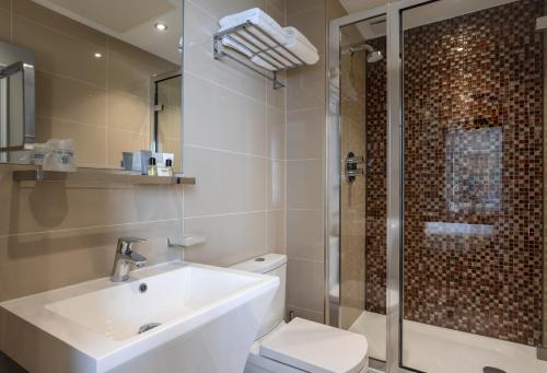a bathroom with a sink and a toilet and a shower at Sidney Hotel London-Victoria in London