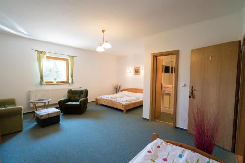 a living room with a bed and a chair and a bedroom at Pension U Stříbrného Jelena in Cheb