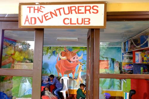 a sign for the adventurers club in a book store at The Great Rift Valley Lodge & Golf Resort in Naivasha