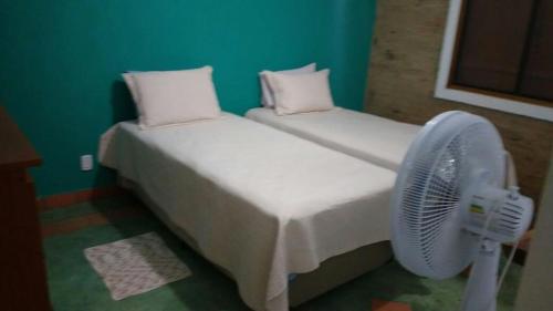 a bedroom with two beds and a fan at Cachoeira do santo Antônio in Delfinópolis