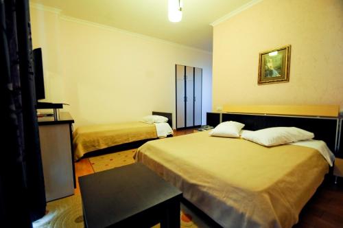 a hotel room with two beds and a television at Hotel Lubjana in Tirana