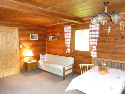 a living room with a white couch in a log cabin at Ferienhaus Unterkircher-Wallner in Heiligenblut