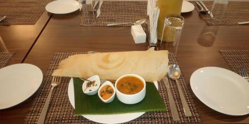 a plate of food with soup and bread on a table at WelcomHeritage Ashdale in Nainital