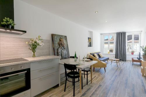 une cuisine et un salon avec une table et des chaises dans l'établissement UnSejourAmetz-fr Meublés Ossons du T2 au T4 avec parking,, à Metz