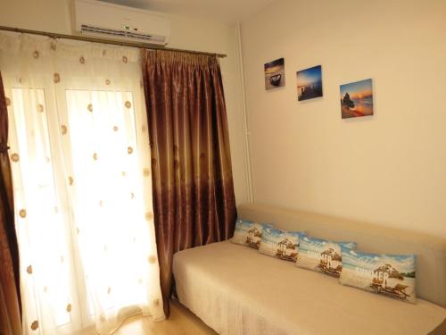 Schlafzimmer mit einem Bett und einem Fenster mit Vorhängen in der Unterkunft Nice studio next to the sea in Athen