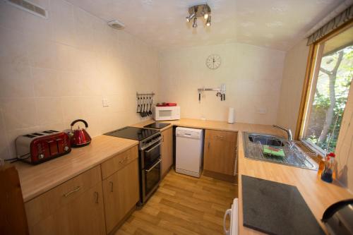 a small kitchen with a stove and a microwave at Invercauld Lodges in Ballater