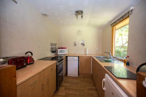 a small kitchen with a stove and a refrigerator at Invercauld Lodges in Ballater