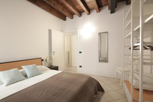 a white bedroom with a bed and a ladder at INTERNO 4 - central cozy new flat in Desenzano del Garda