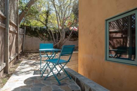 two chairs and a table outside of a house at The Little Pumpkin Guest House in San Diego