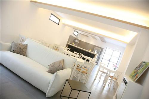 Cantina Loft في كييتي: غرفة معيشة مع أريكة بيضاء ومطبخ