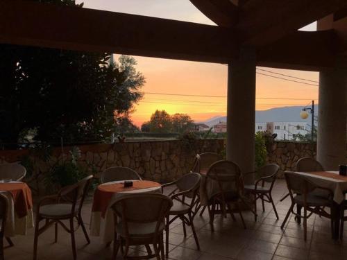 a patio with tables and chairs and a sunset at Agriturismo Terre Delle Monache in Pontecagnano