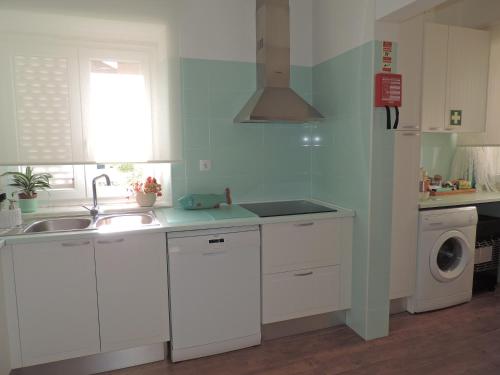 una cucina con lavello e lavatrice di BLISS WHITE HOUSE a Sintra