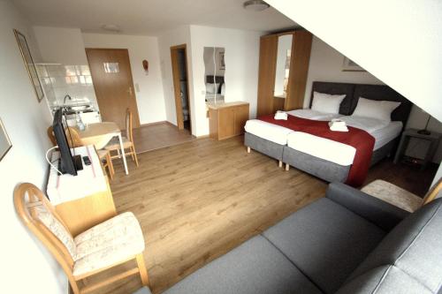 a hotel room with a bed and a living room at Hotel Leo Mühlhausen in Mühlhausen