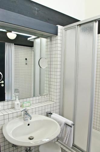 a white bathroom with a sink and a shower at Hotel Paffhausen in Wirges