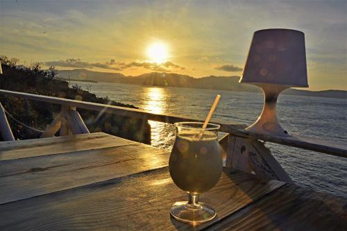 a drink on a table with the sunset in the background at Solazul in Las Galeras
