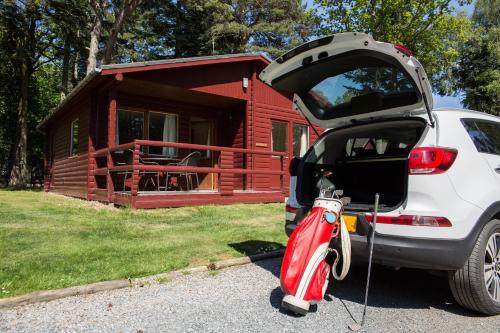 a car with its trunk open in front of a cabin at Invercauld Lodges in Ballater