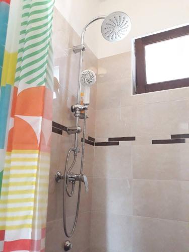 a shower in a bathroom with a rainbow shower curtain at Studio apartman Rest Nest in Čakovec