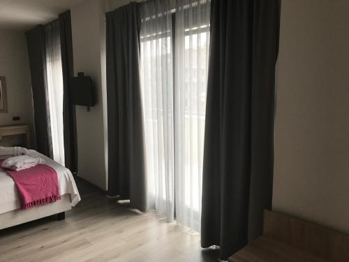 a bedroom with a bed and a window with curtains at Superior One Boutique Hotel in Thessaloniki