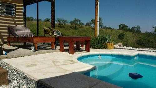 a swimming pool with a picnic table and a bench at Balcones de Molinari in Cosquín