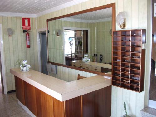 a bathroom with a mirror and a counter with wine bottles at Hostal Oasis in Fraga