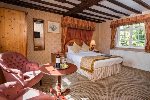 a hotel room with a bed and a table and chairs at Marston Farm Hotel in Sutton Coldfield