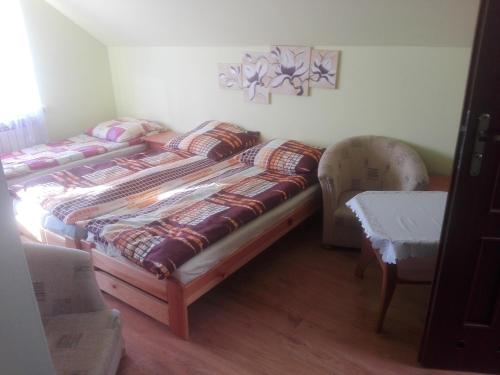 a bedroom with two twin beds and a table at Agroturystyka u Tadka in Klęczany