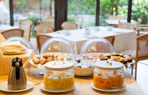 マリーナ・ディ・ピエトラサンタにあるHotel Andreaneriの蜂蜜の瓶とペストリーが置かれたテーブル