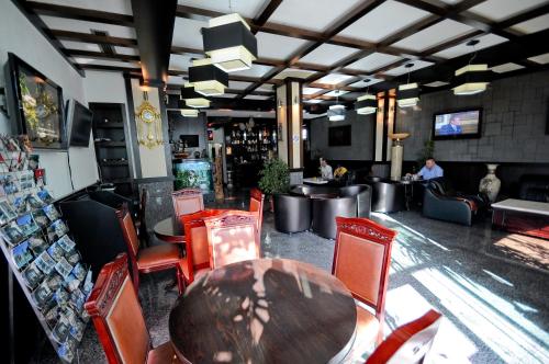 een restaurant met een tafel en stoelen en een bar bij Hotel Lubjana in Tirana
