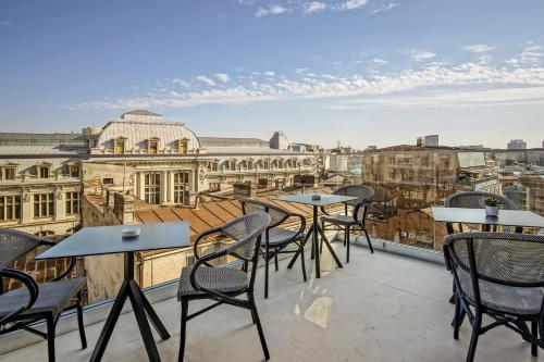 a balcony with tables and chairs and a view of the city at Filitti Boutique Hotel in Bucharest