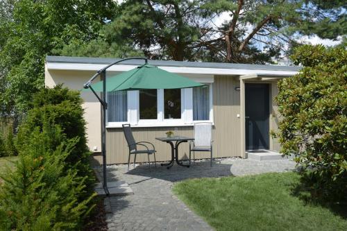 a small shed with a table and a green umbrella at Ferienquartier Goethe33 in Dresden