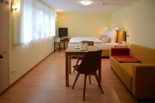 une chambre d'hôtel avec un lit, une table et un canapé dans l'établissement Ferienquartier Goethe33, à Dresde