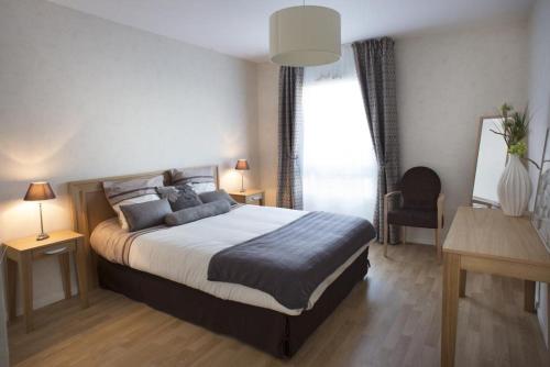 - une chambre avec un grand lit et une fenêtre dans l'établissement Domitys - Résidence Services Seniors - Le Havre Nord, à Montivilliers
