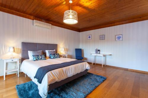um quarto com uma cama grande e um tecto de madeira em Casa do Casalinho em Avelar