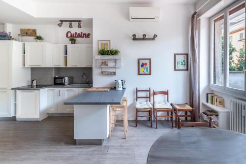 een keuken met witte kasten en een tafel en stoelen bij Milano Homey Apartment in Milaan