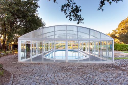 a glass house with a pool in it at Casa do Casalinho in Avelar