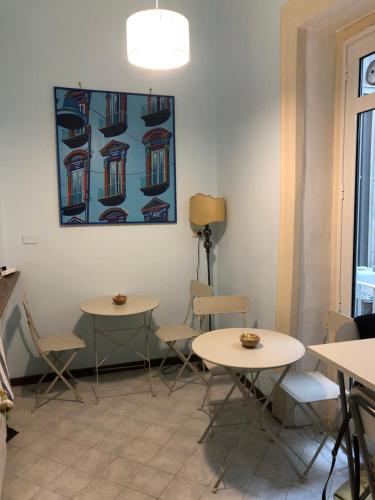 una habitación con mesas y sillas y un cuadro en la pared en BnB Naples, en Nápoles